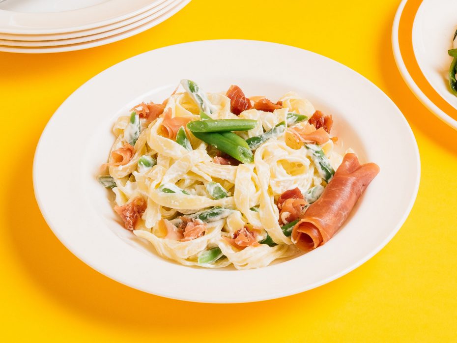 Tagniatelle in a white wide rimmed pasta plate