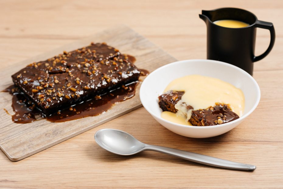 Chocolate Cake with Custard in White Bowl with Black Small Jug