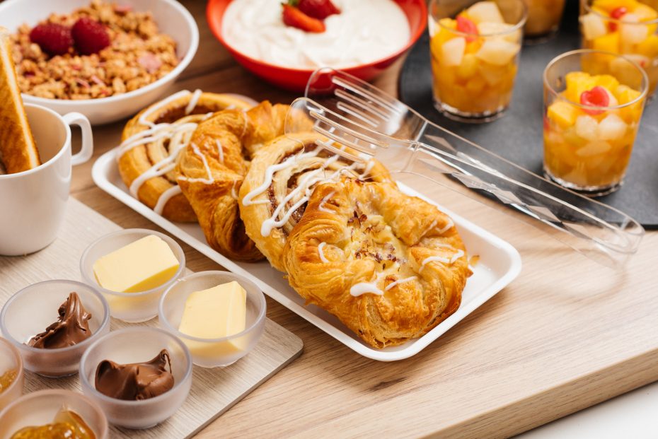 Pastries on white food platter and with serving tongs