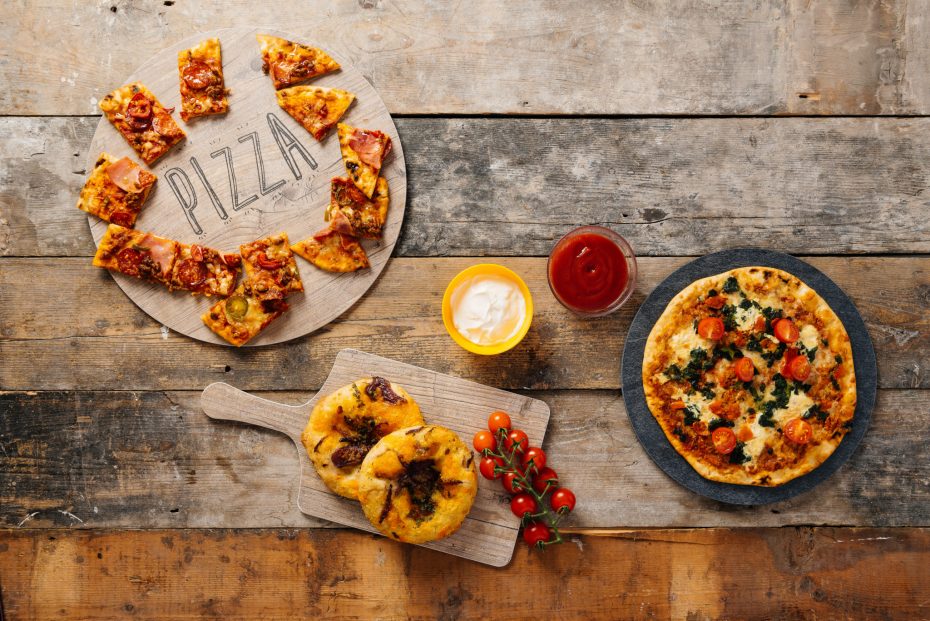 Pizza on a round vintage wood and slate food platters