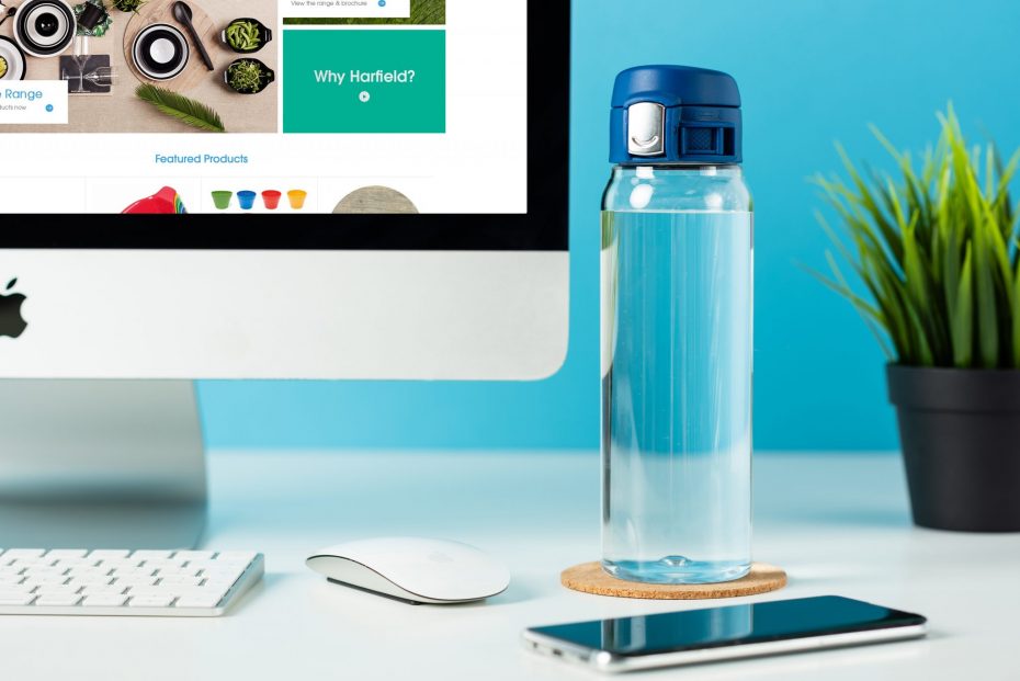 Water Bottle with Blue Sports Cap at a Computer Desk