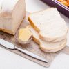 Bread and Butter on Chopping Board with a Silver Knife