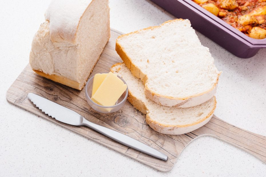 Bread and Butter on Chopping Board with a Silver Knife