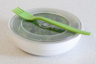 Salad Served in a White Bowl with Round Clear Lid