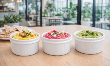 Colourful hummus dips in white ramekins in modern canteen